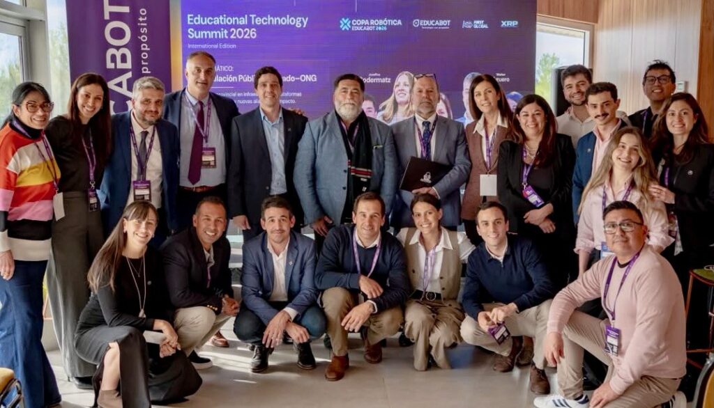 Oradores y equipo del Educational Technology Summit 2026, con Gustavo Riesgo, ante la pantalla del encuentro en el Centro de Convenciones Domuyo, Neuquén